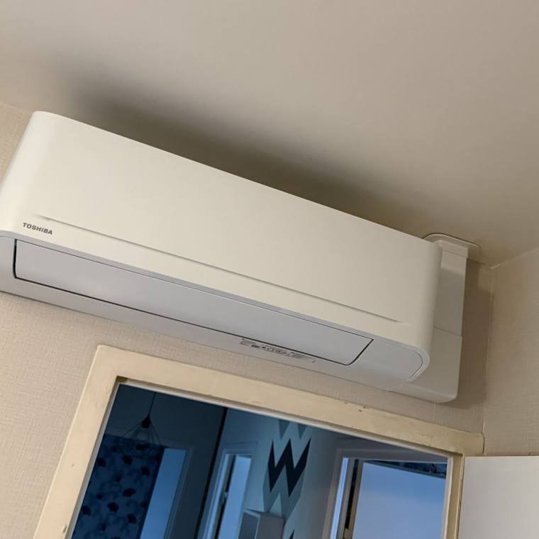 Unité murale de climatisation Toshiba installée dans une chambre à Dijon